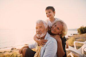 grandparents on beach with grandchild.