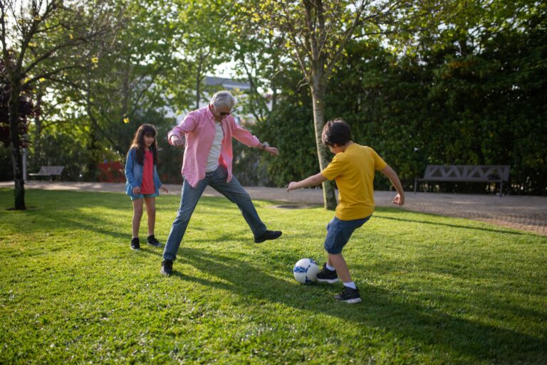 grandparent playing soccer with kids