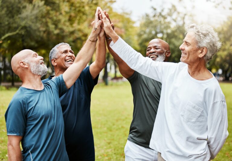 group of older aged men high-fiving each other