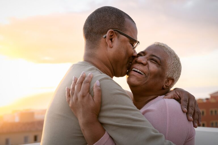 older aged couple kissing on cheek